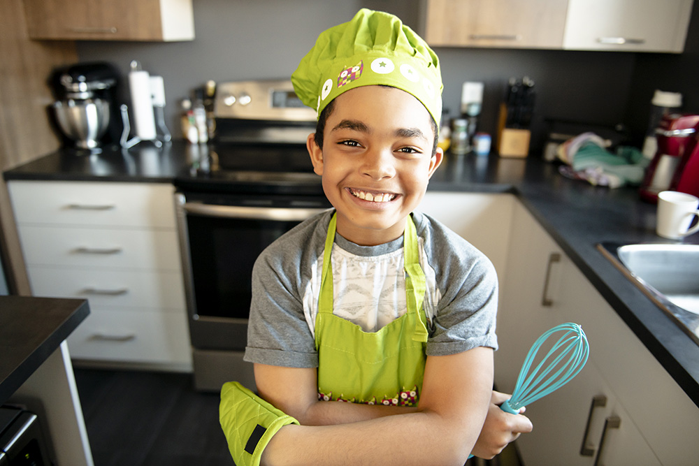 Nice little kid in chef hat at kitchen